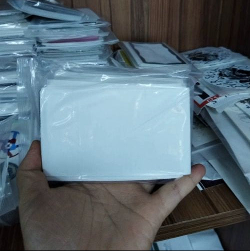Hand holding stack of white eggshell stickers from sample pack